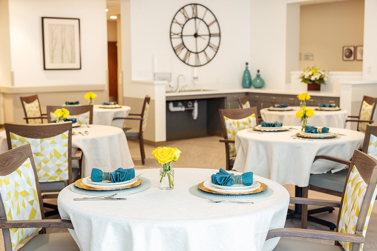 The dining tables set with linen tablecloths and soft seating at the Pacific Villas facility
