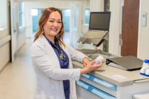 A caregiver standing at the nurse's cart in the hallway at the Pacific Villas facility