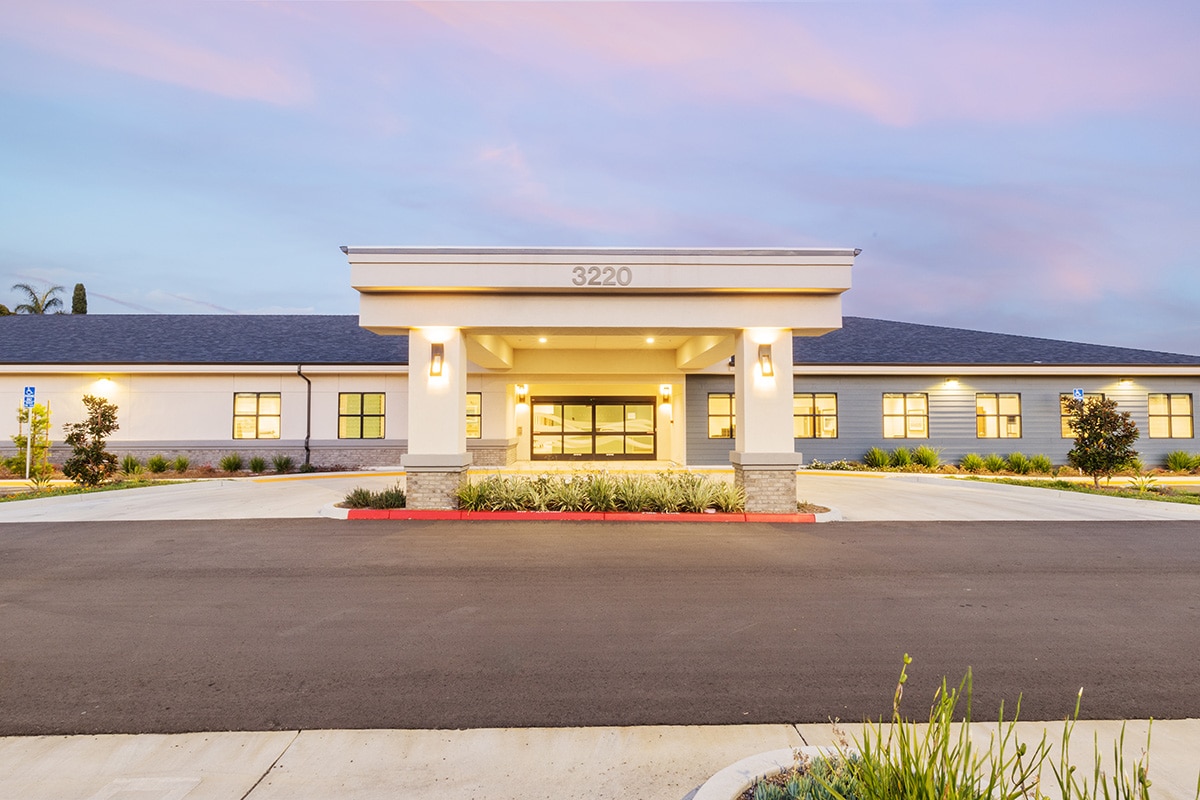 The front of the Pacific Villas facility with cotton candy clouds overhead
