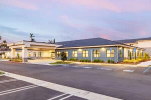 Front of the Pacific Villas facility with cotton candy clouds overhead