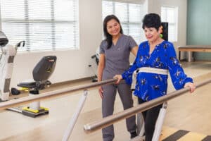 Rehab therapists with a resident in the gym at the Pacific Villas facility