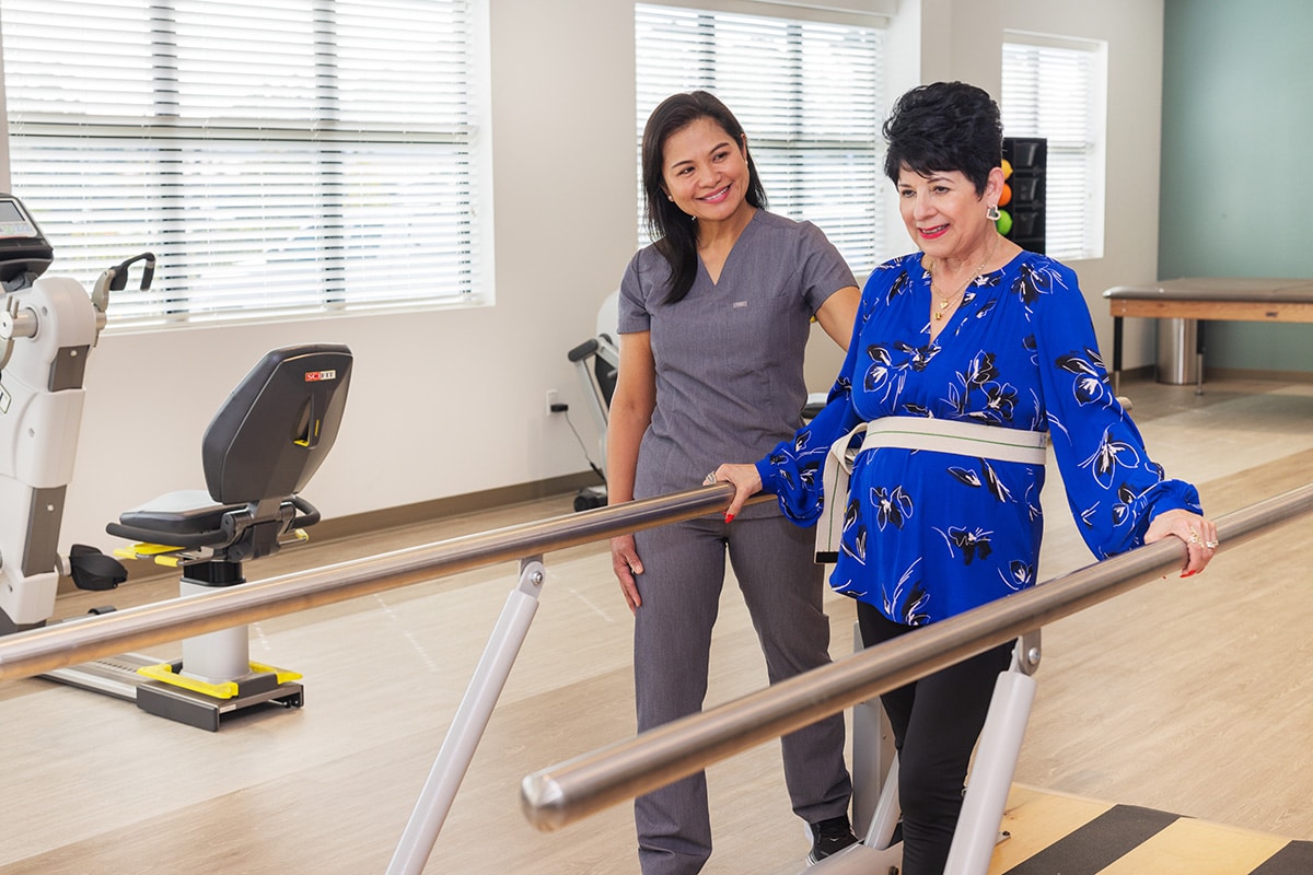 Rehab therapists with a resident in the gym at the Pacific Villas facility