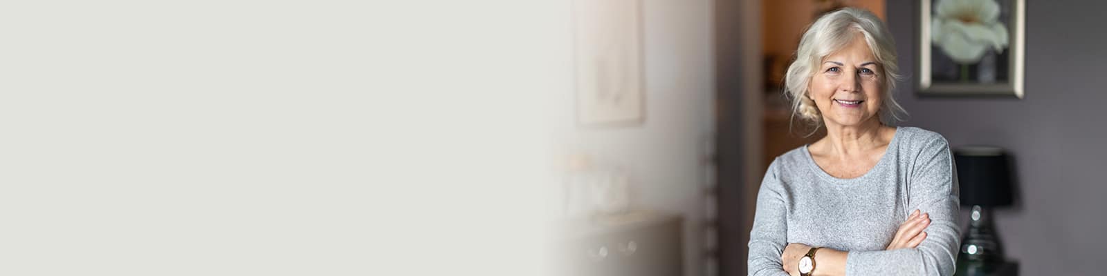 A senior with her arms folded smiling.